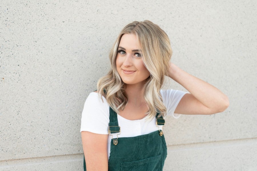 Photo of Ashlyn Grayce standing in front of wall. 