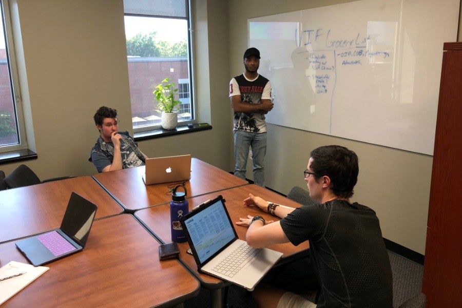 Students sitting at table working. 