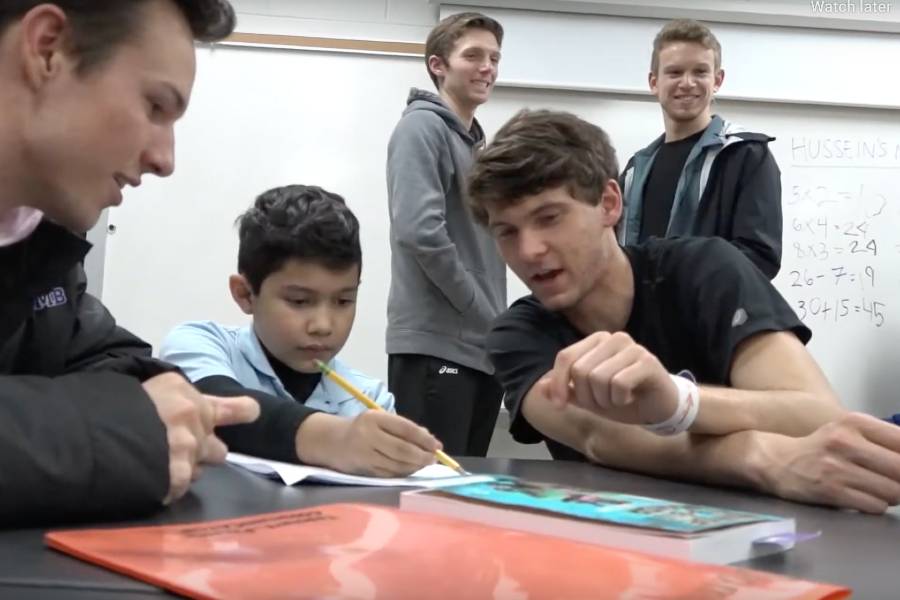 Student athletes with elementary student.