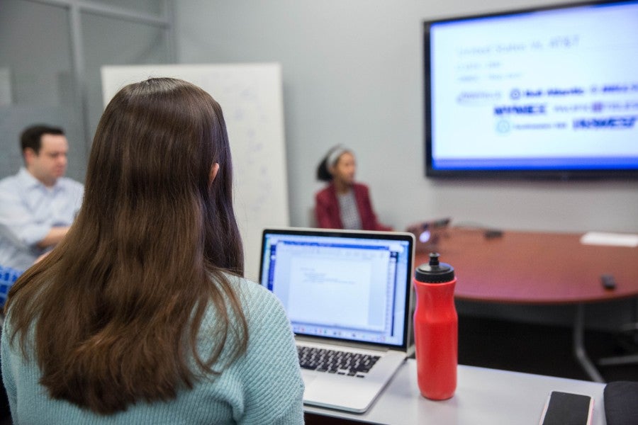 Three students sitting in computing classroom