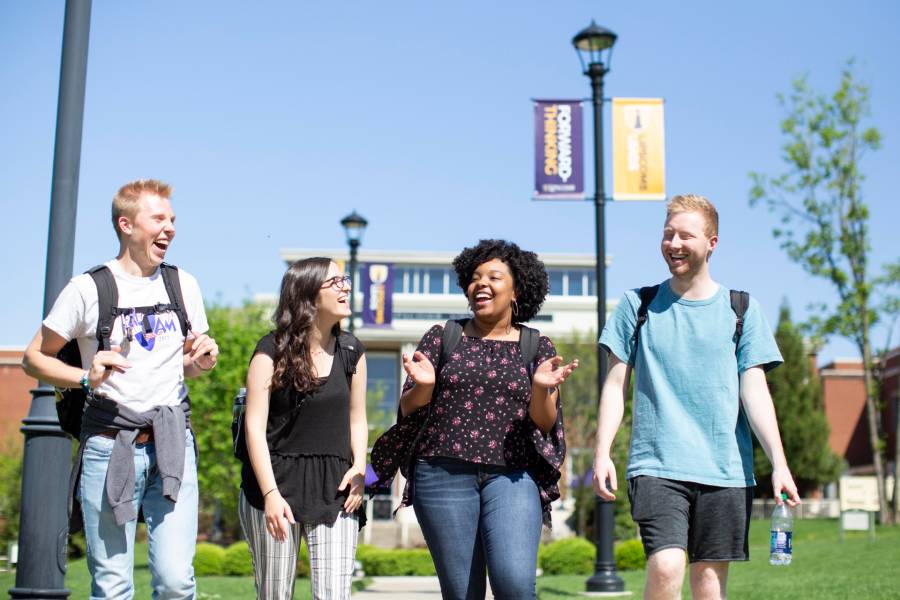 Photo of four students walking on campus