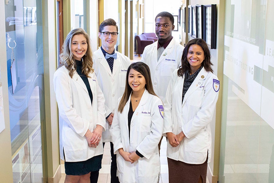 Health science students posing in a hallway