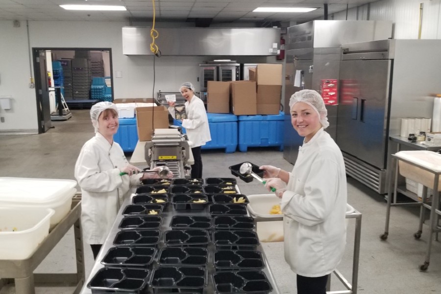 Two Lipscomb dietetic interns filling food trays in the Second Harvest kitchen