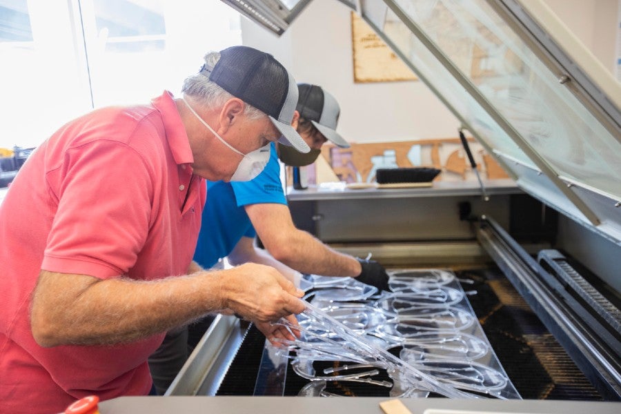 Peugeot engineers at the laser cutter making face shields