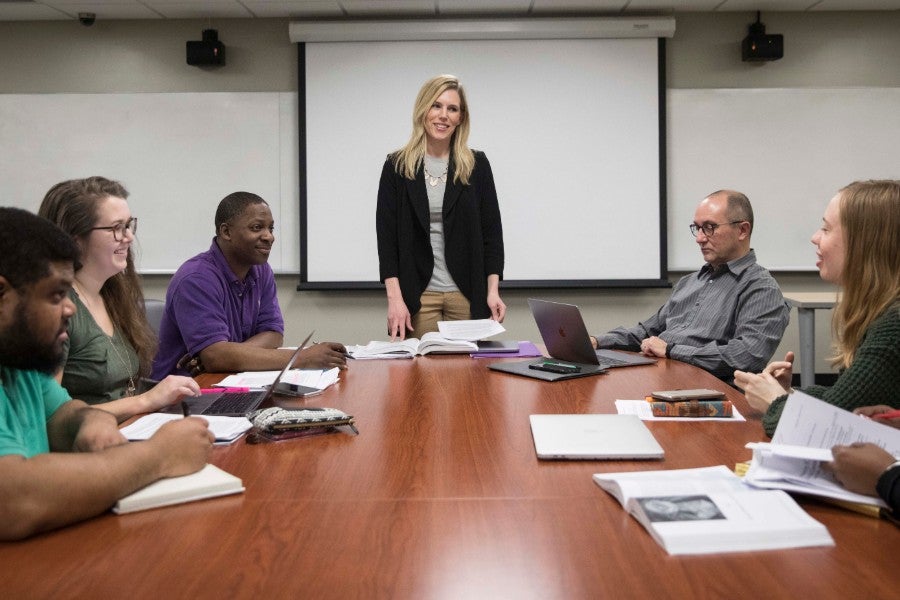 Professor standing at table with class