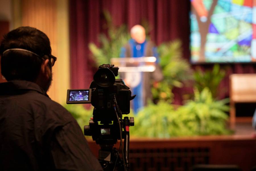 Camera filming baccalaureate in Collins Alumni Auditorium