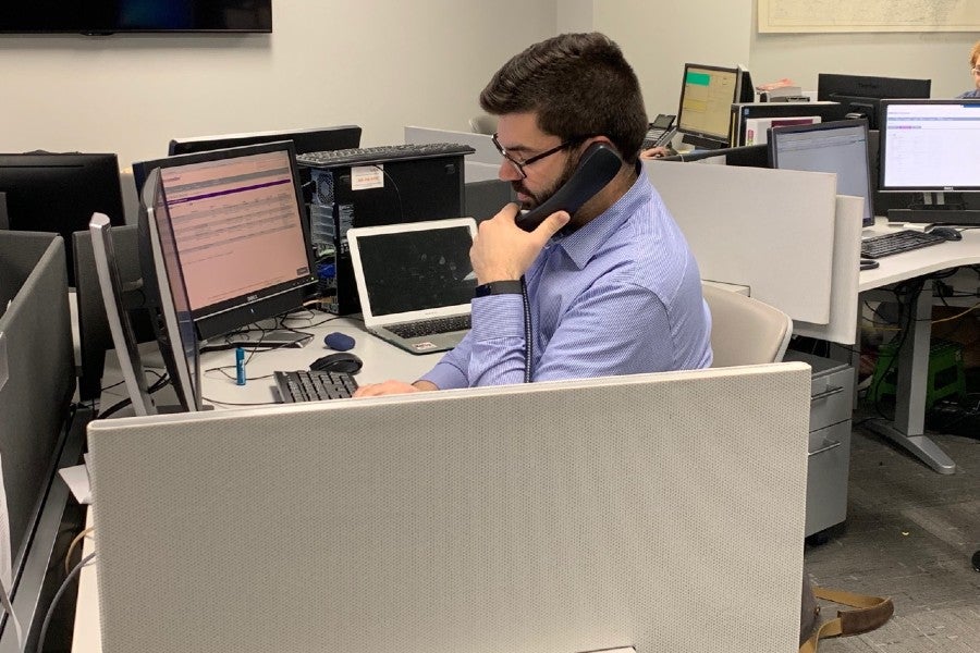 Student sitting at desk manning phones.