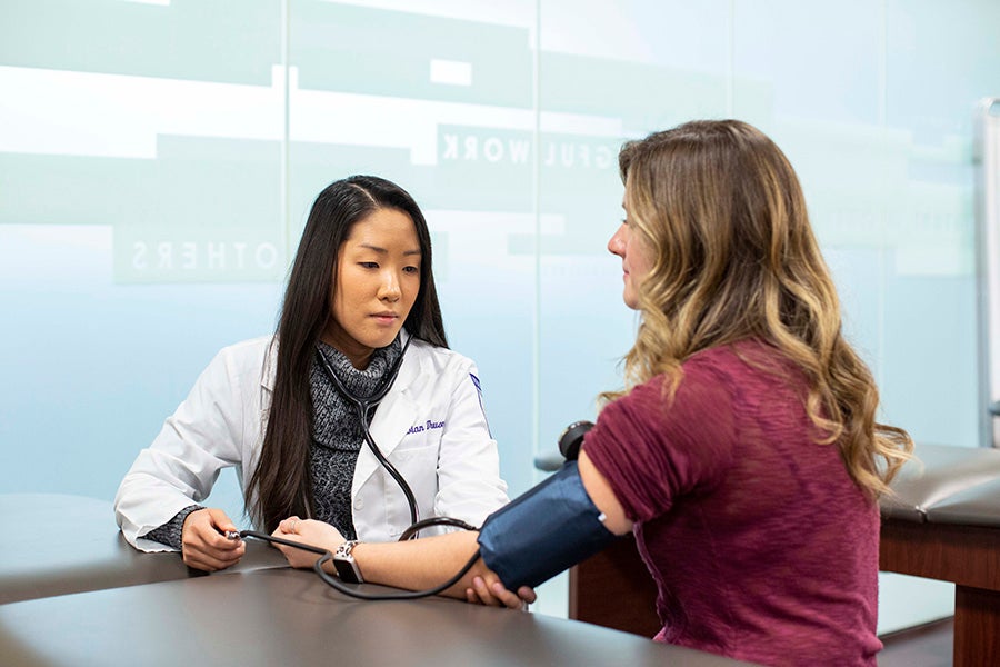 A health science student takes a patient's blood pressure