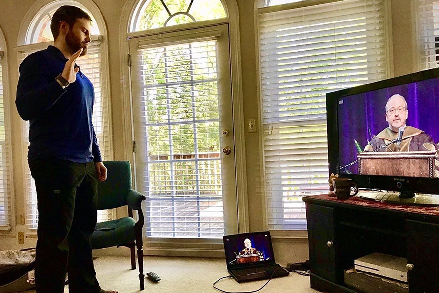 Pharmacy graduate reciting the oath of a pharmacist at home during the virtual recognition ceremony