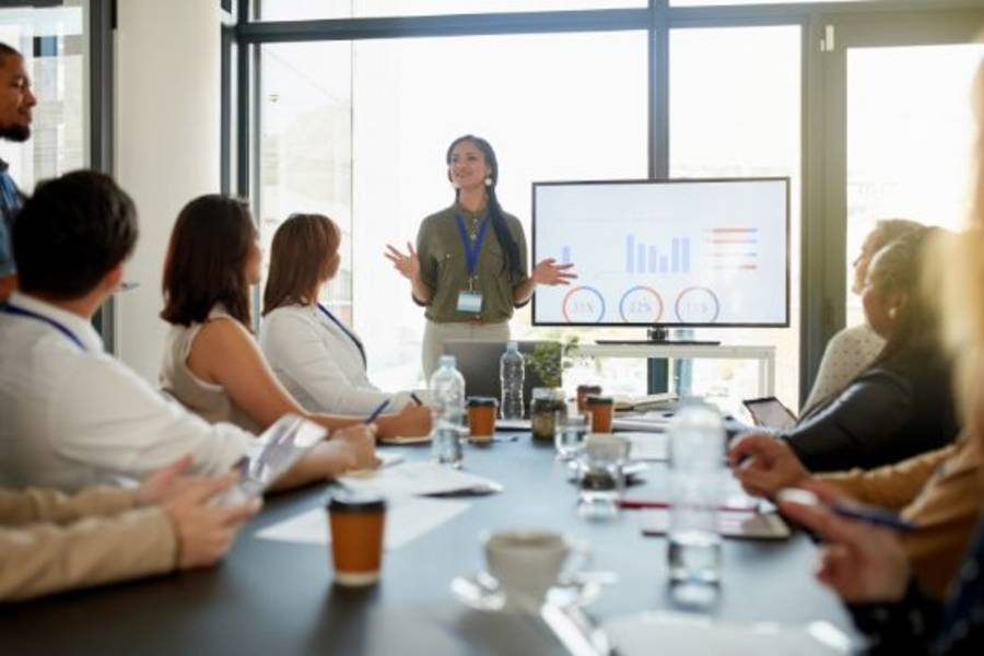 Group of employees sitting in a board room in a meeting.