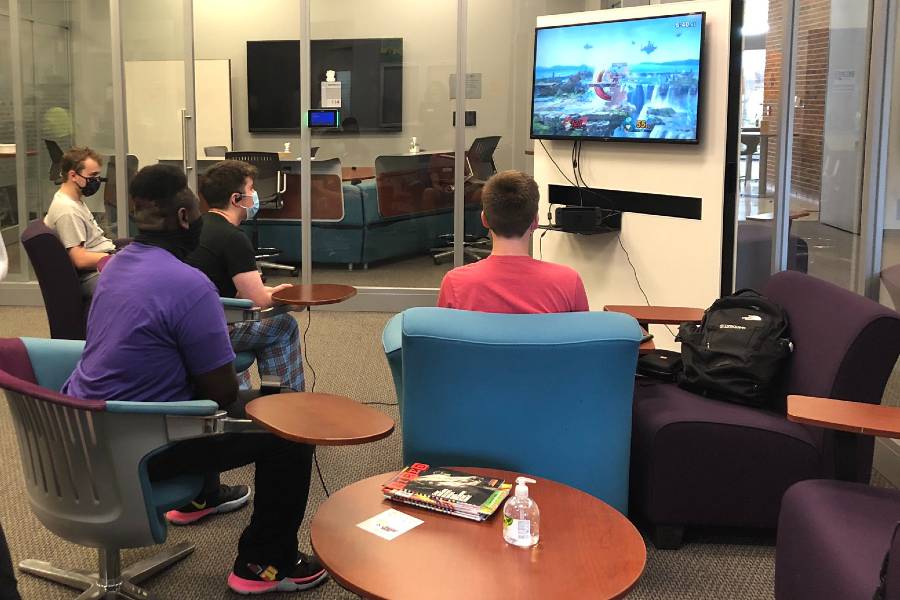 Students sitting in gaming cave playing video games.