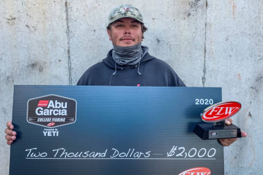 Photo of student holding check for winning fishing tournament.
