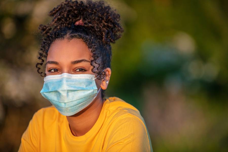 Photo of young woman in a face mask outside