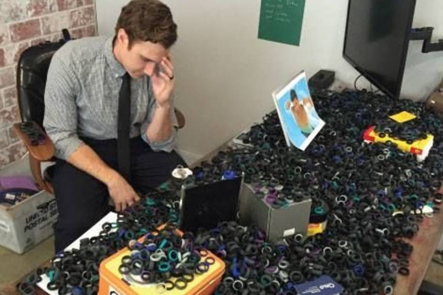 Kc Holiday at a desk with thousands of silicone rings. 