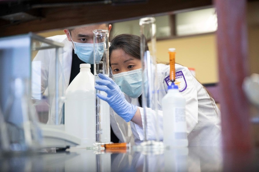 Two students compounding head sanitizer