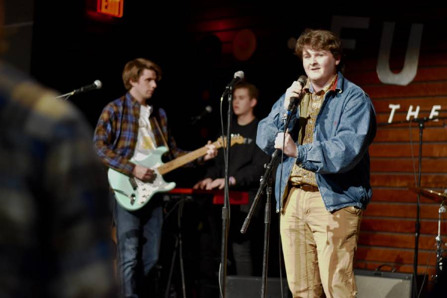 Three students on stage performing