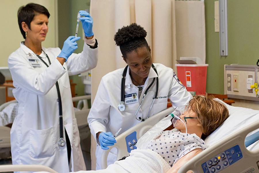 Nursing professor and student working with SIM mannequin 