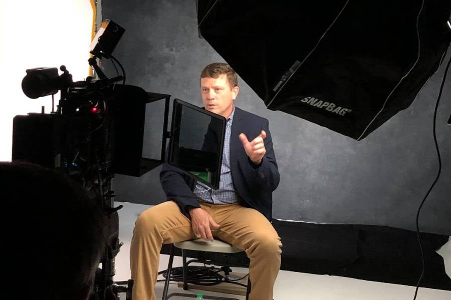 Steele sitting in front of video camera