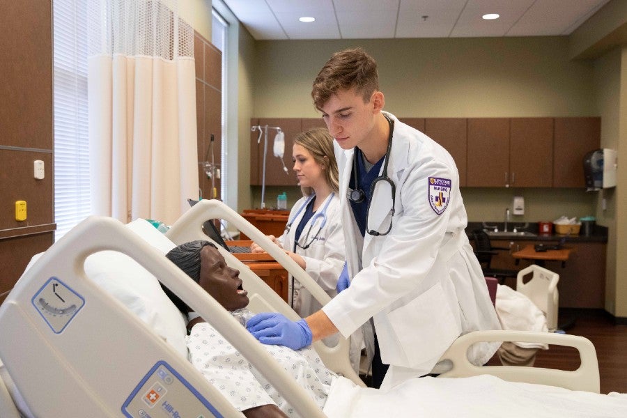 Nursing students in the simulation lab with patient simulator