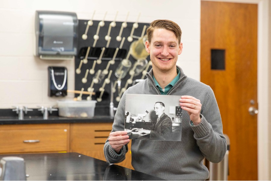 Josh Owens in McFarland lab with a photo of his grandfather Willis Owens