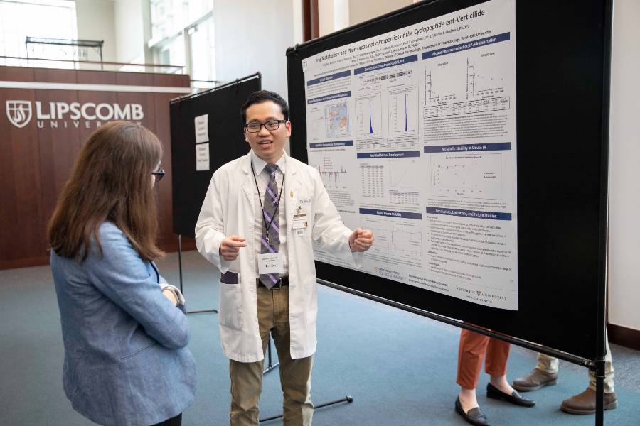 Student describes poster at symposium