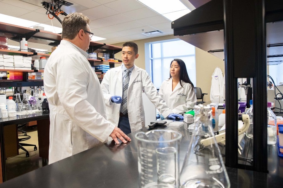 Dr. Scott Akers with alumni Kangjun Li and Vivian Truong