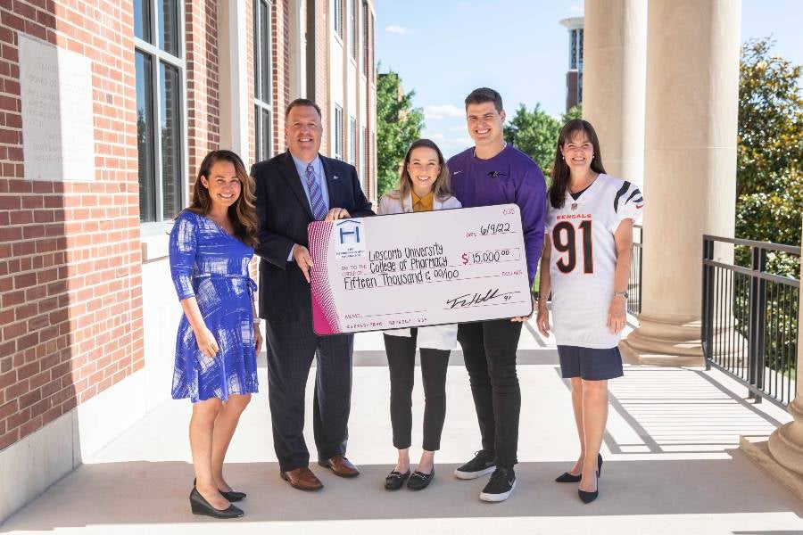 College of Pharmacy Dean Tom Campbell with Trey and Alisa Hendrickson for a presentation of a gift for an upcoming mission trip. 