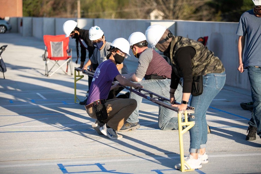 Engineering students working on a bridge