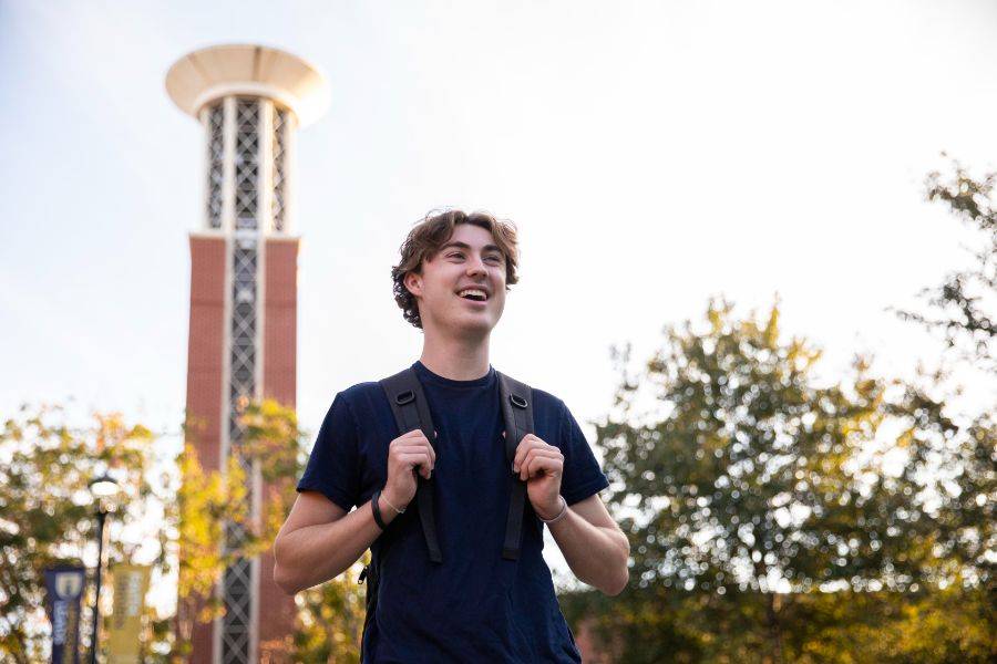 Student standing in front of Allen Bell Tower