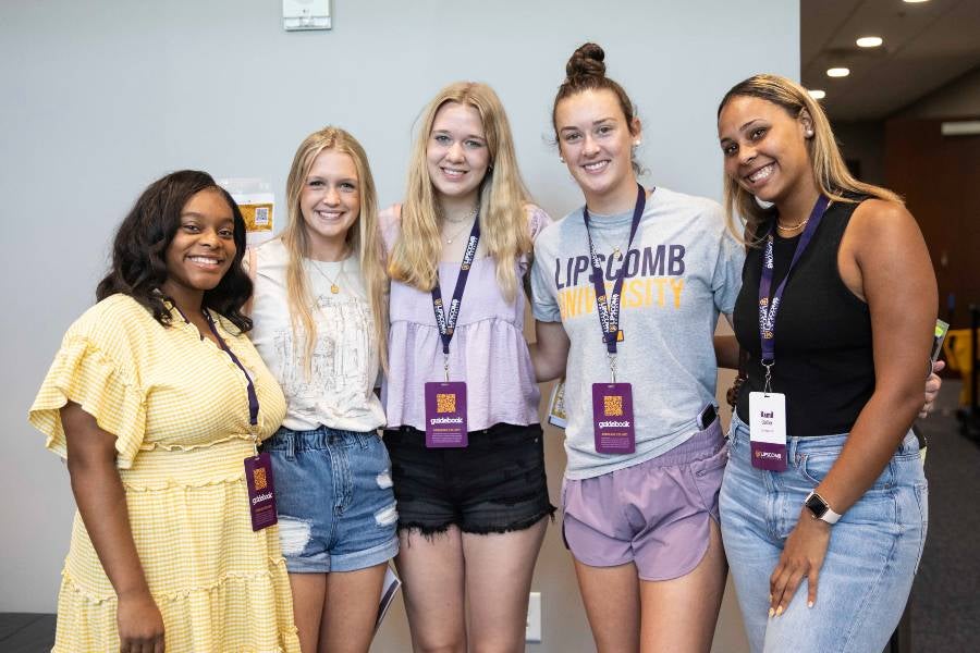 Five students hanging out on campus. 