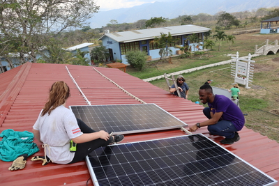 The HOI Team works to install solar panels