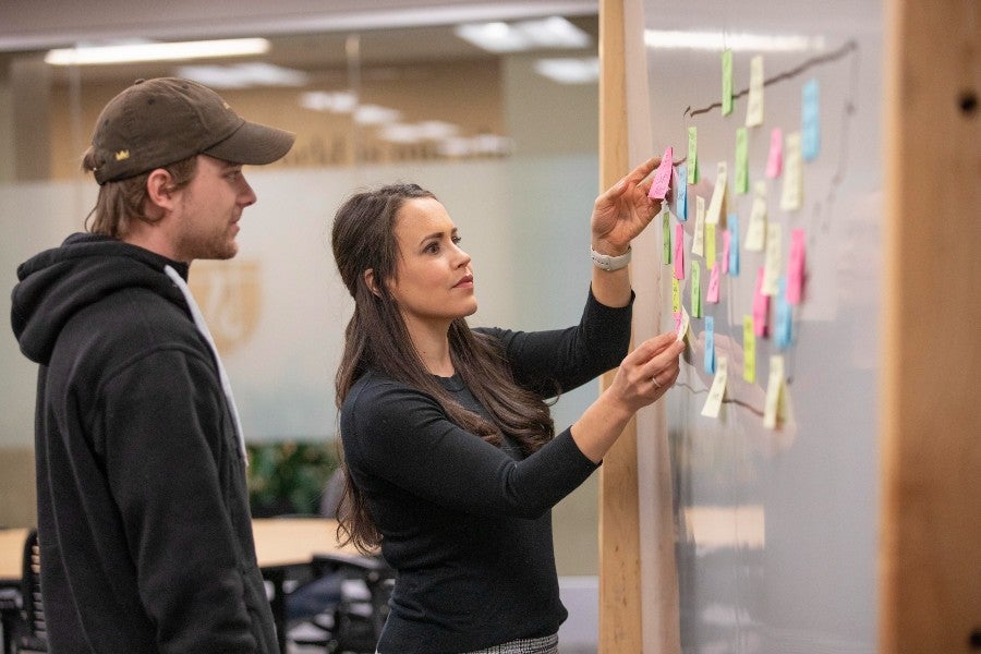 Professor Susan Haynes with students organizing Post-It notes to begin their geographic database project