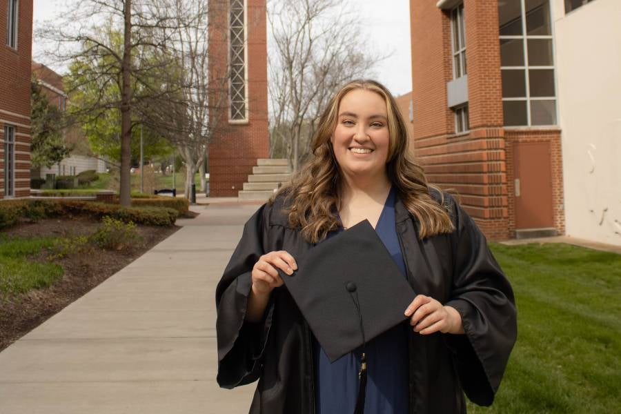 Celia Hill in her cap and gown on the Lipscomb campus.