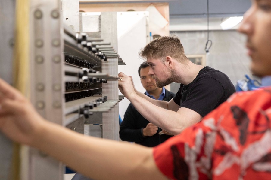 Students work with Assistant Professor David Collao on the engineering college's wind tunnel