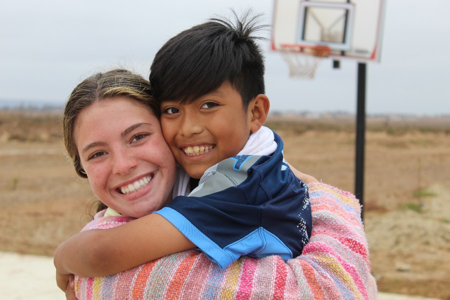 Student playing with child on a mission trip 