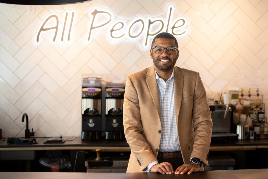 Bradley Bruce standing behind the counter of All People Coffee