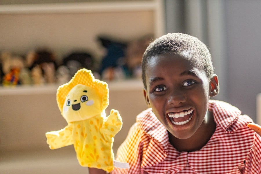 Girl at The Have with a bright yellow puppet on her hand