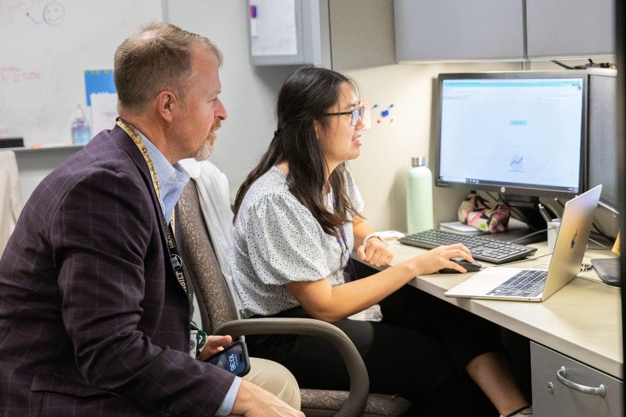 Dr. Eris Grogan training Carolyn Tran on database work