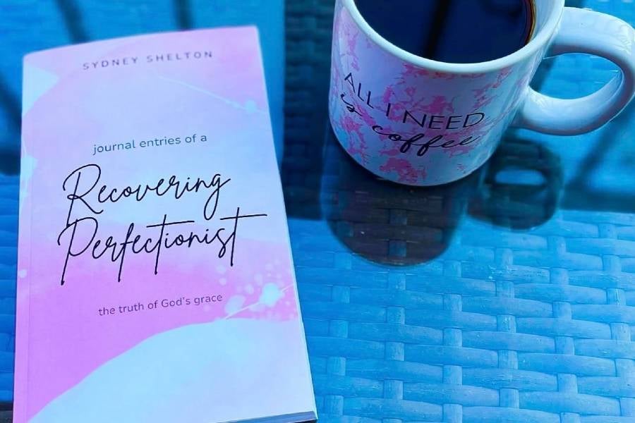 Photo of a book written by Sydney Shelton and a cup of coffee.