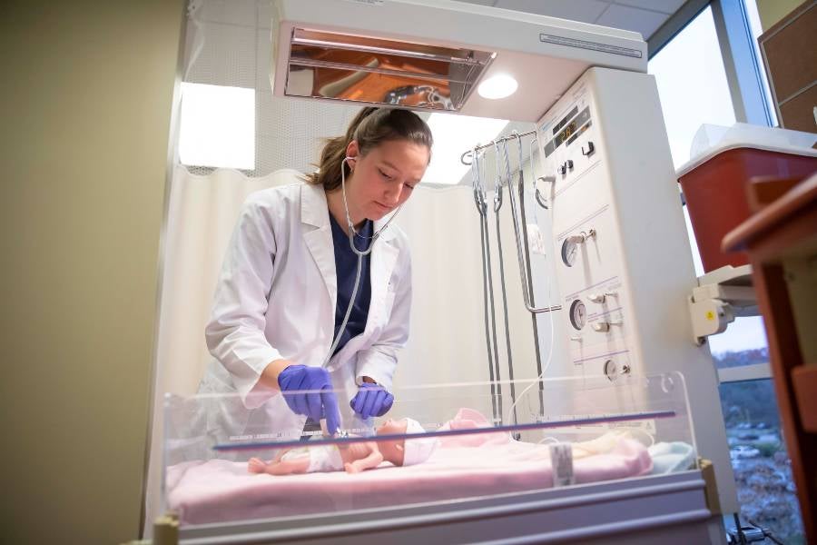 Nursing student working in simulation lab.