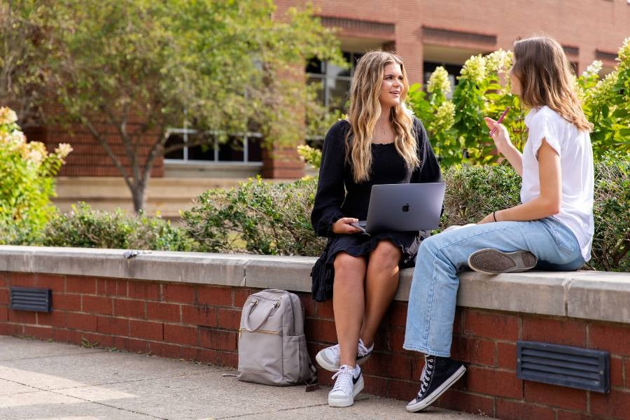 Two students studying near the bell tower.