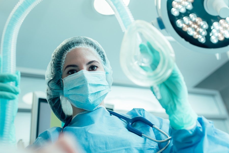 Anesthesiologist putting a mask on a patient