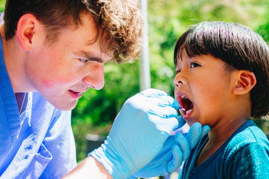 Lipscomb student checks a Guatemalan child's teeth