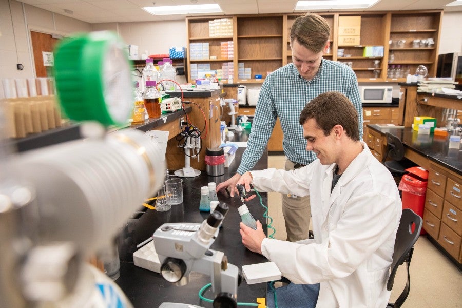 Professor Josh Owens works with Ward Fellow Jackson Head in the biology lab