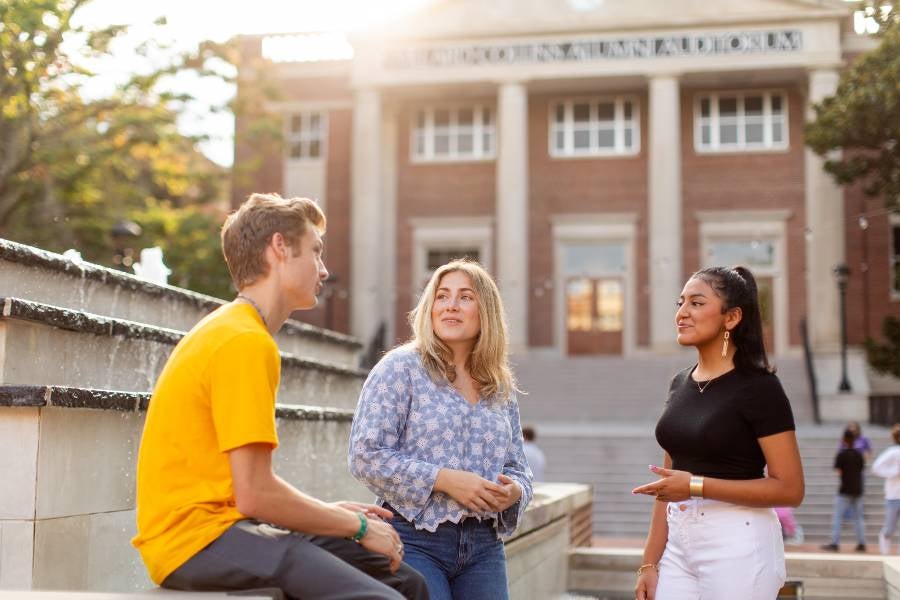 Students sitting in Bison Square on the fountain.