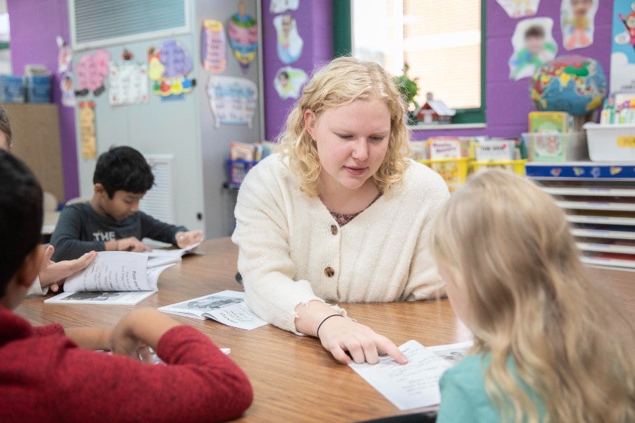 Lipscomb student aiding younger students in reading