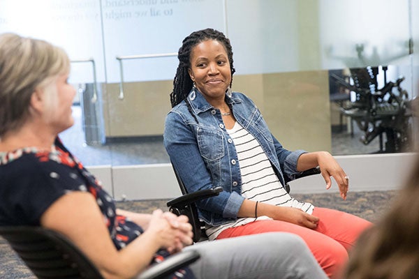 Two woman converse during a group discussion