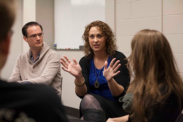 A woman leads discussion among other professionals