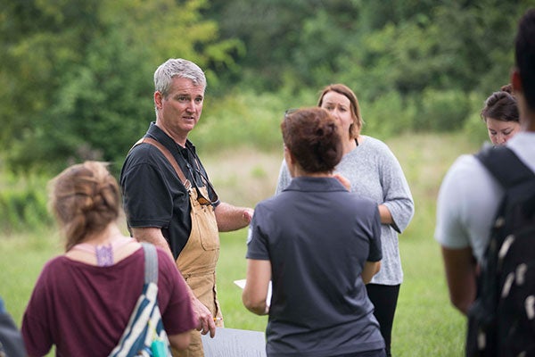 A professor teaches his students while studying in nature