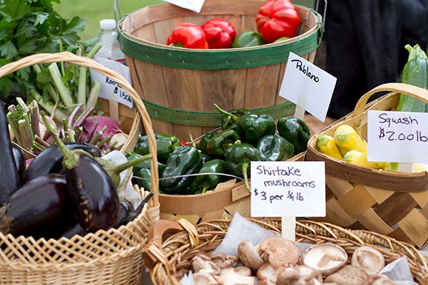 Multiple baskets full of different vegetables sitting on a table